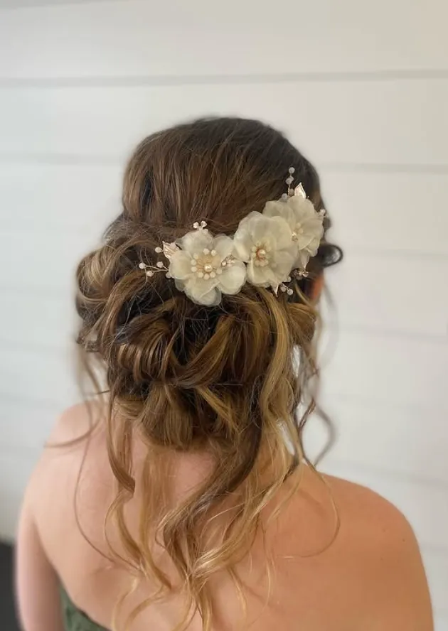 Textured bridal updo dressed with ivory flower pins