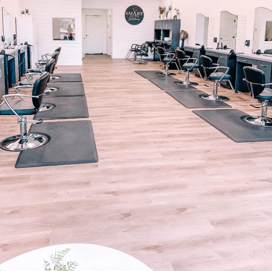 The Smart Cuts salon floor, styling chairs down both walls under the shop's wall sign